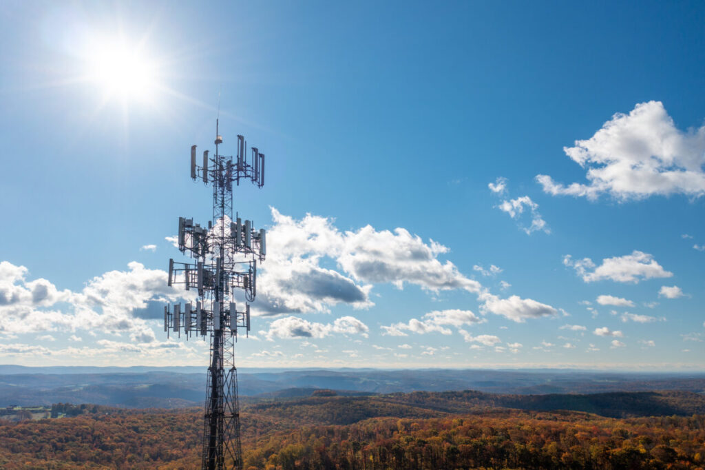 Aerial view of mobile phone cell tower over forested rural area of West Virginia to illustrate lack of broadband internet service